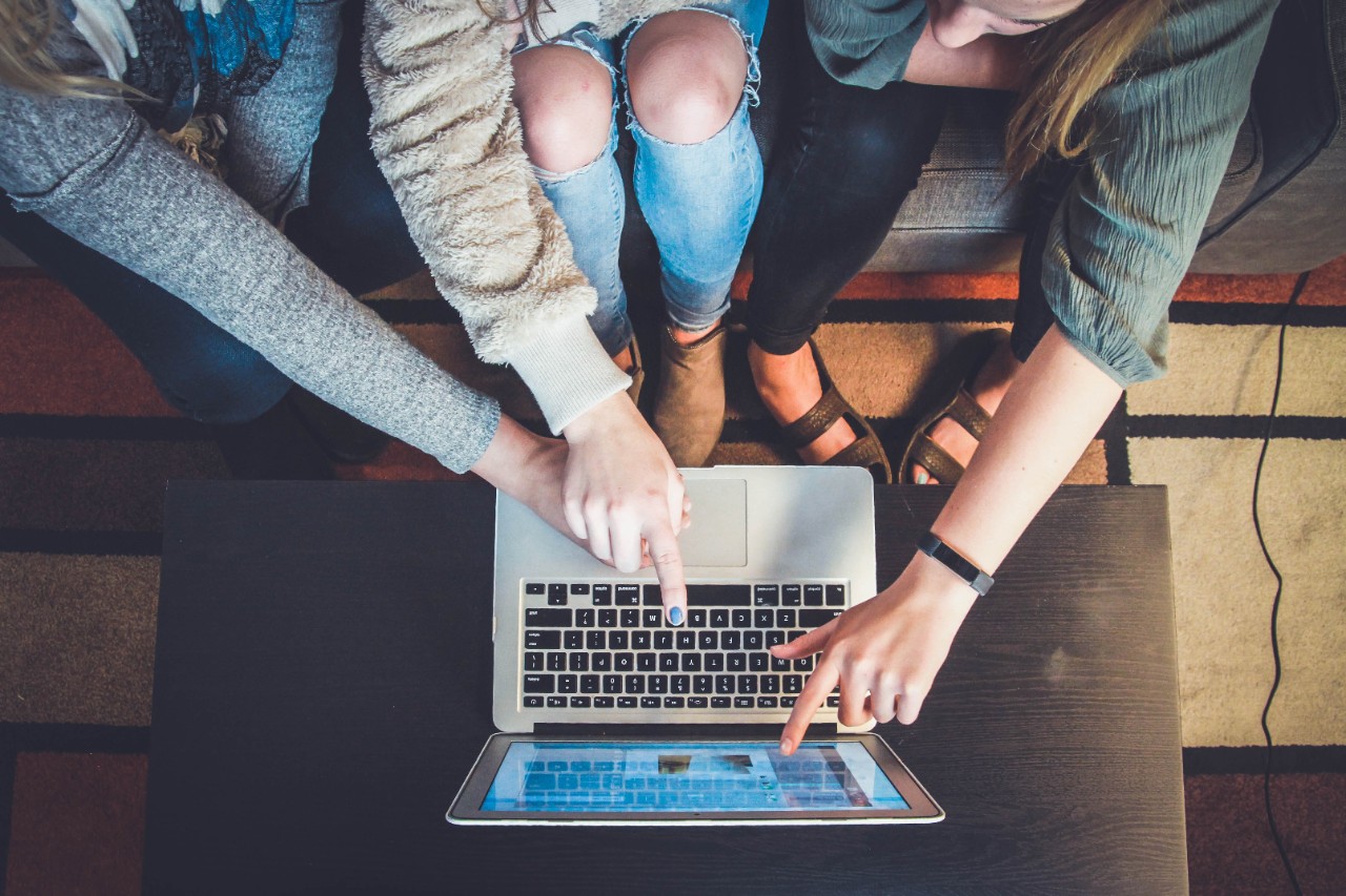 multi people pointing to a computer