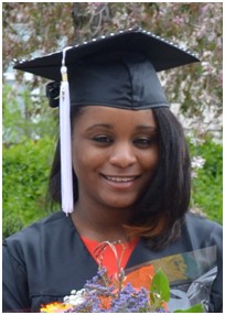 Photo of Andraya wearing graduation cap and gown holding flowers