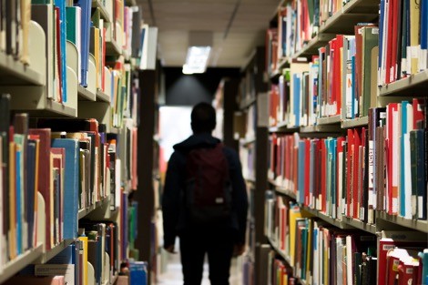 Person walking through library stacks
